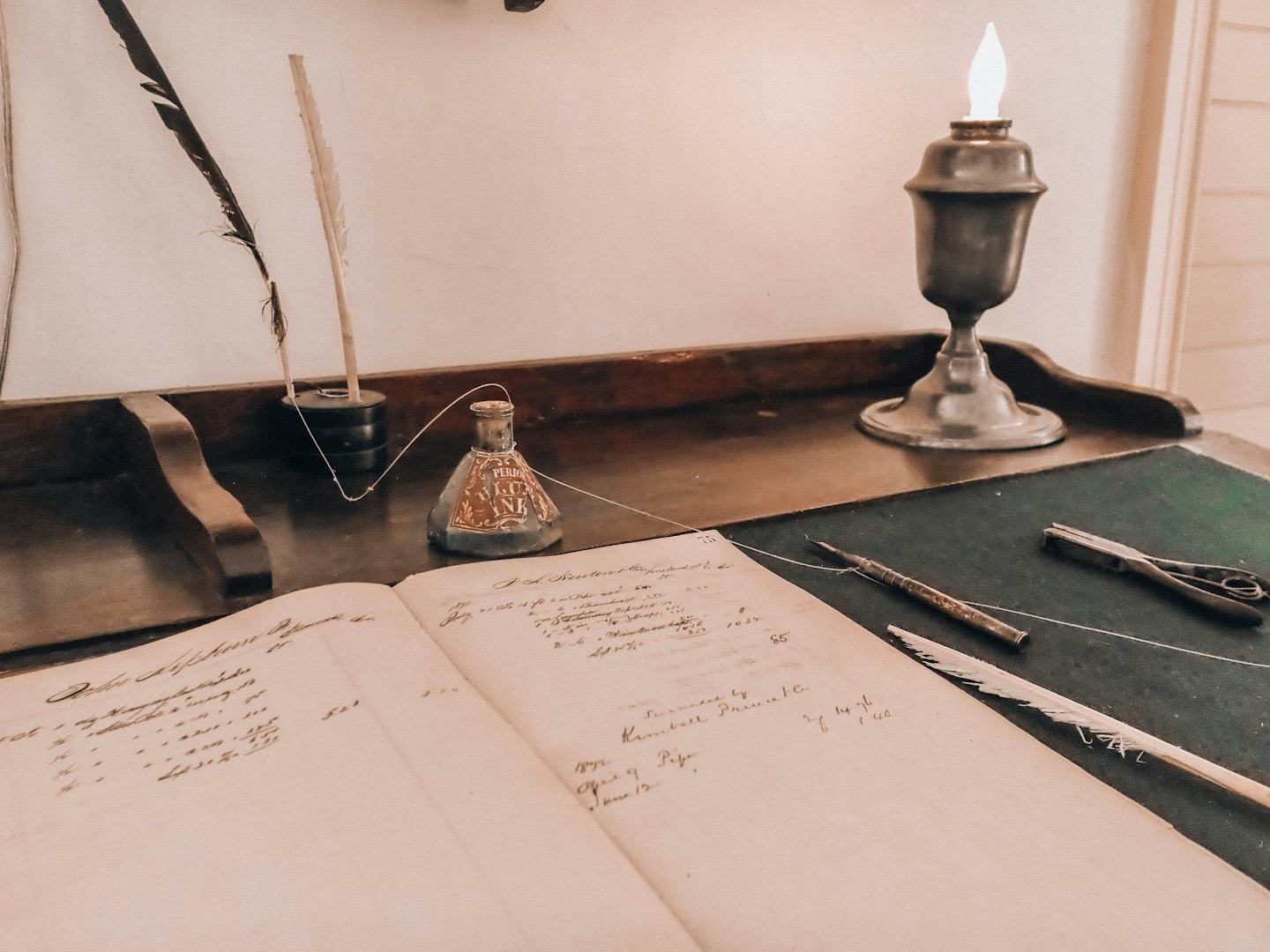 Antiker Schreibtisch mit Kassenbuch, Federkielen und Öllampe.