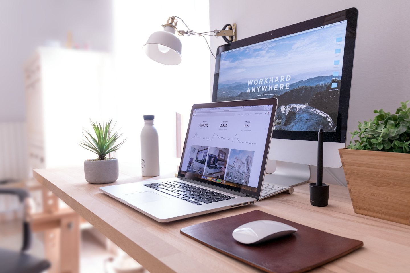 Laptop und Desktop-Monitor auf einem modernen Holztisch.